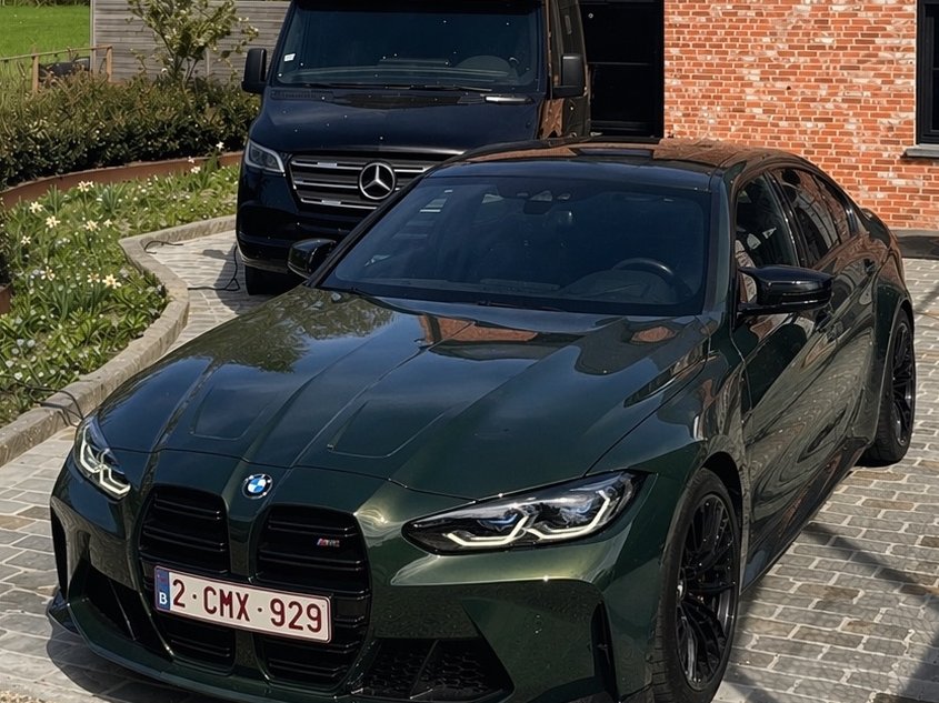 Groene BMW M3 Competition na een complete detail, op een oprit