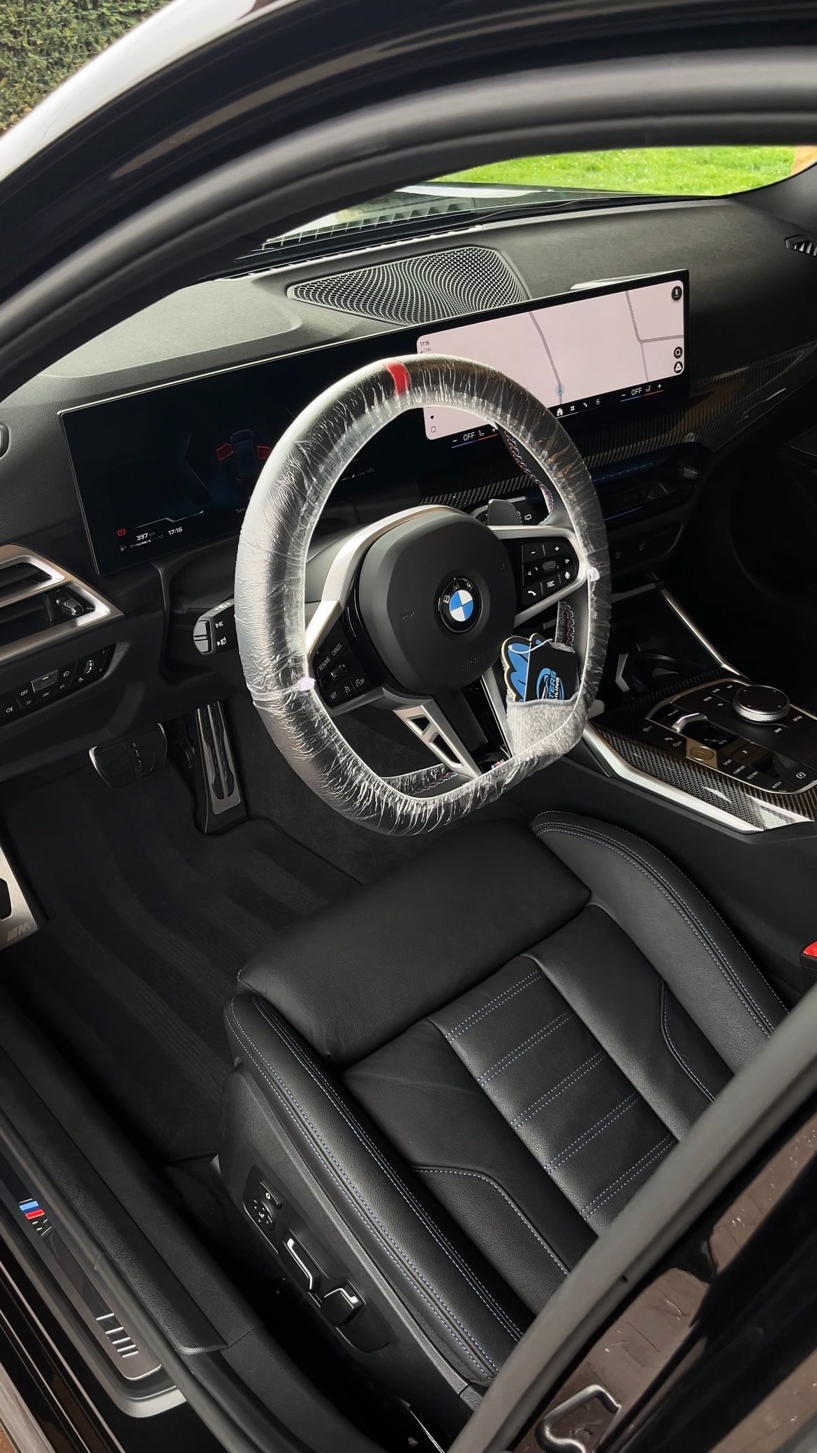 Interieur van een BMW M340i na een interieur detail: zwart leder met blauwe stiksels